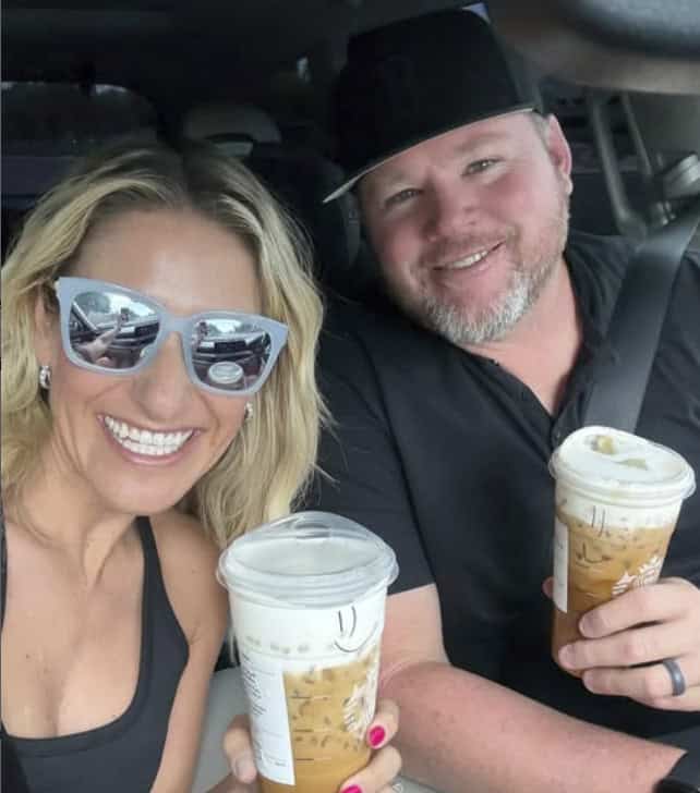 Smiling couple with coffee cups in car, enjoying a moment together.