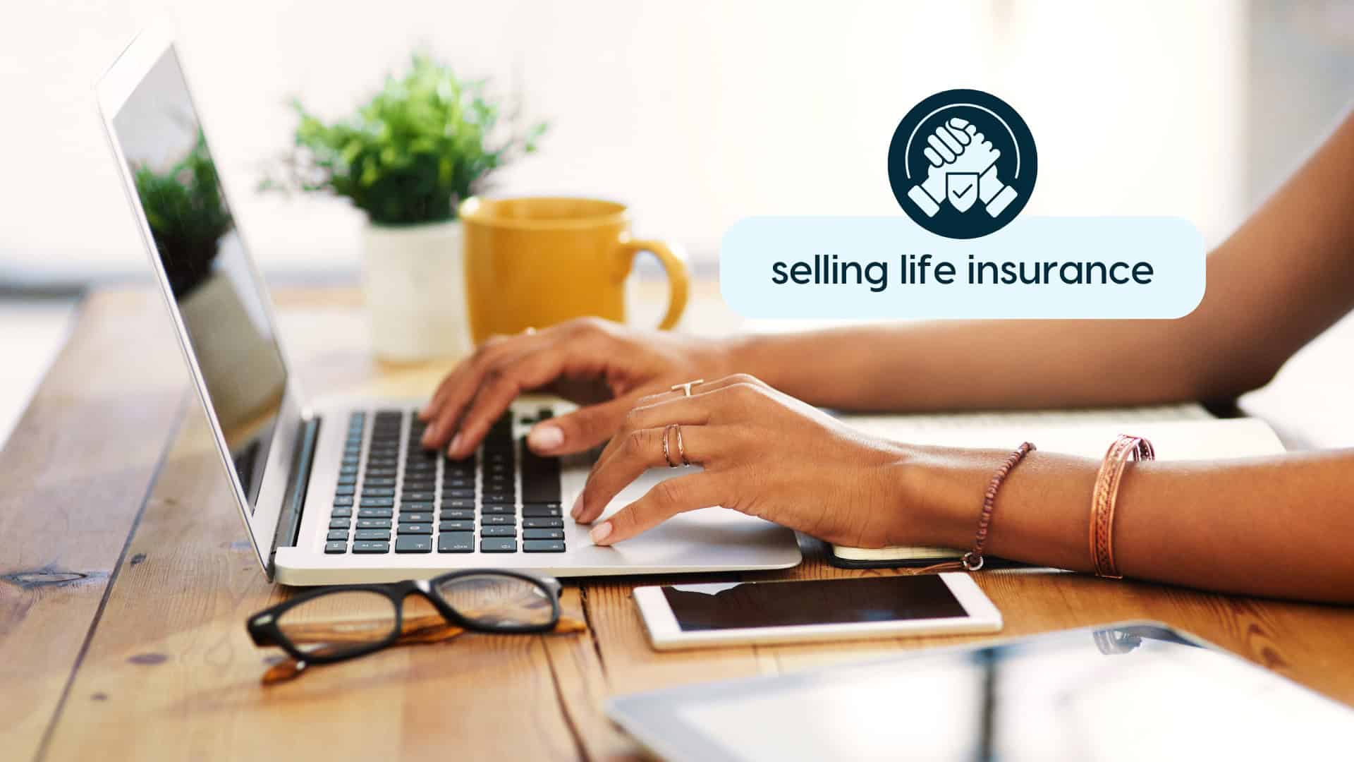 Person working on laptop with selling life insurance icon.